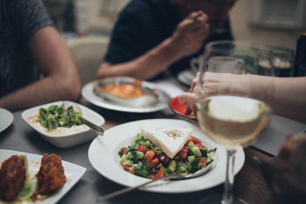 A beautifully arranged dinner setting featuring fresh salad and white wine, perfect for a fine dining experience.